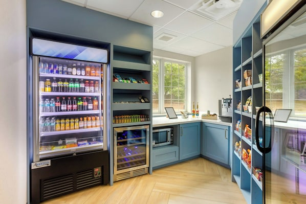 A modern kitchen with a built-in refrigerator, microwave, and a vending machine. - City Express By Marriott King of Prussia (King of Prussia)