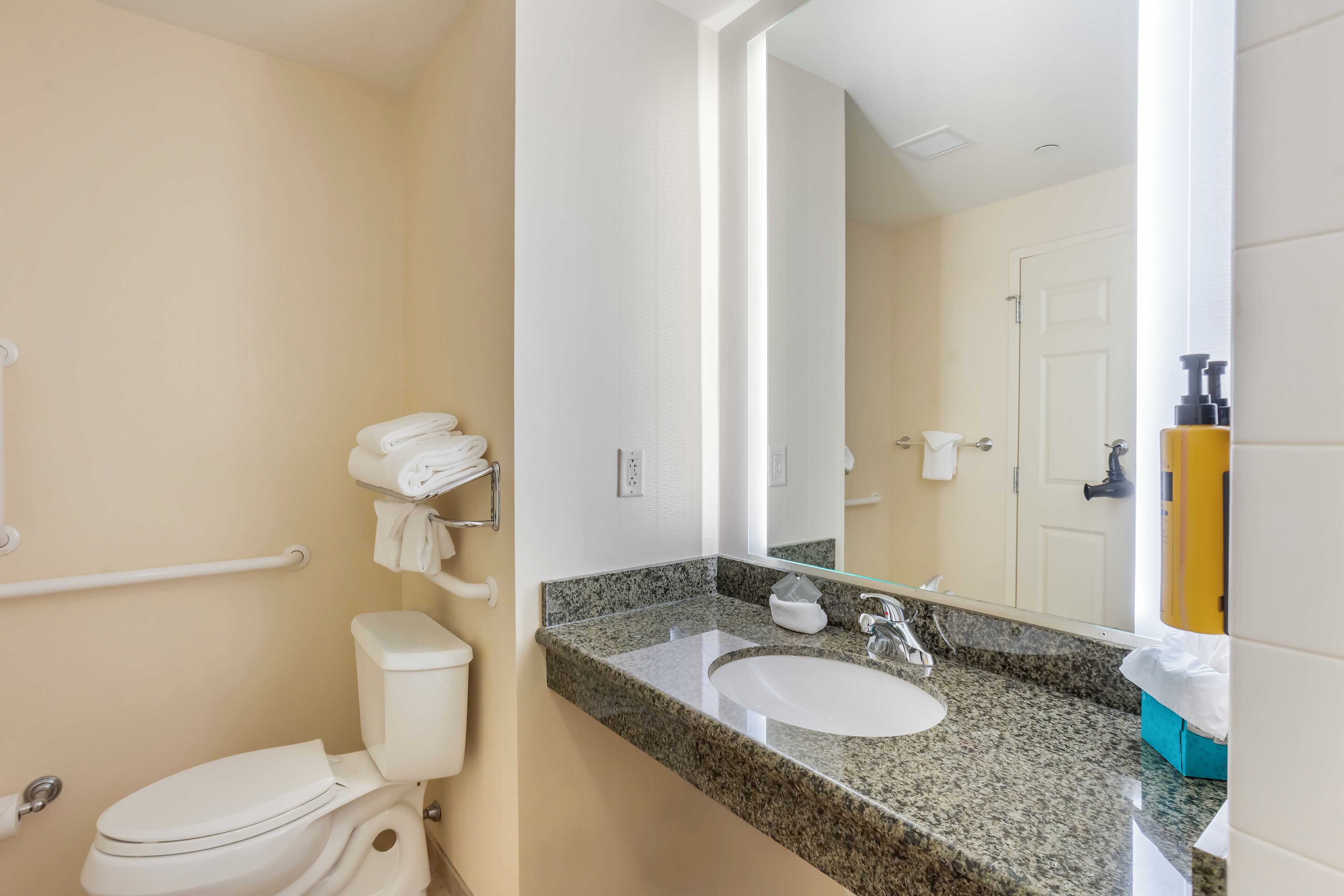 Une salle de bain équipée de toilettes, d’un lavabo et d’un porte-serviettes.