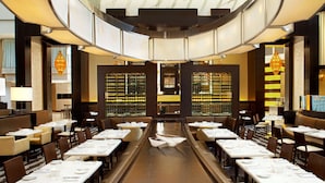 A restaurant with long communal tables, individual booths, and a central bar area.