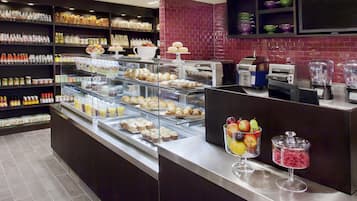 Un présentoir de pâtisserie avec divers produits et un coin café.