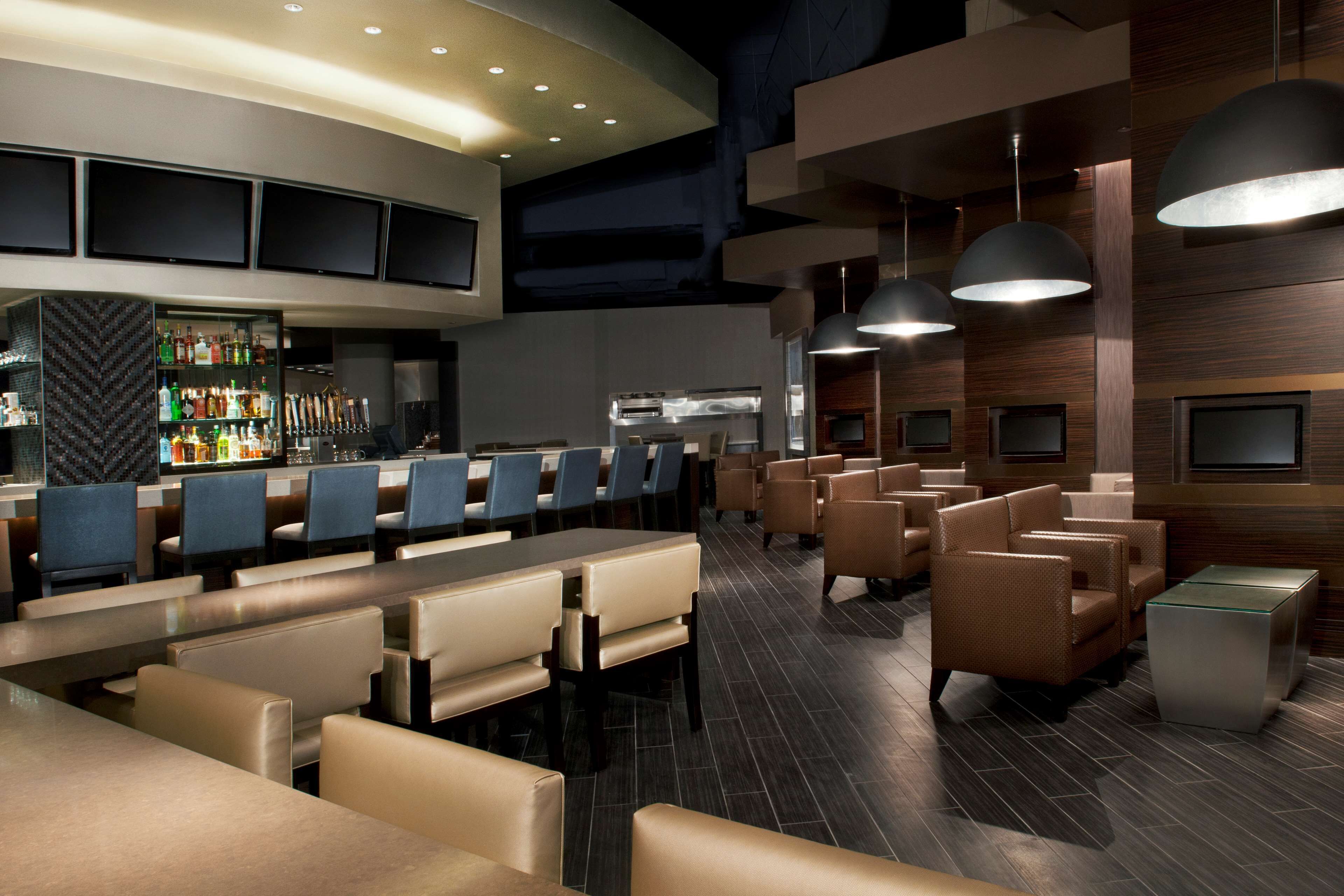 A modern bar area with seating and a bar counter.