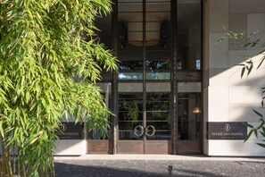 A building entrance with a glass facade, a metal gate, and a sign reading 'INTERCONTINENTAL GENEVE'. - InterContinental Geneve by IHG (Geneva)