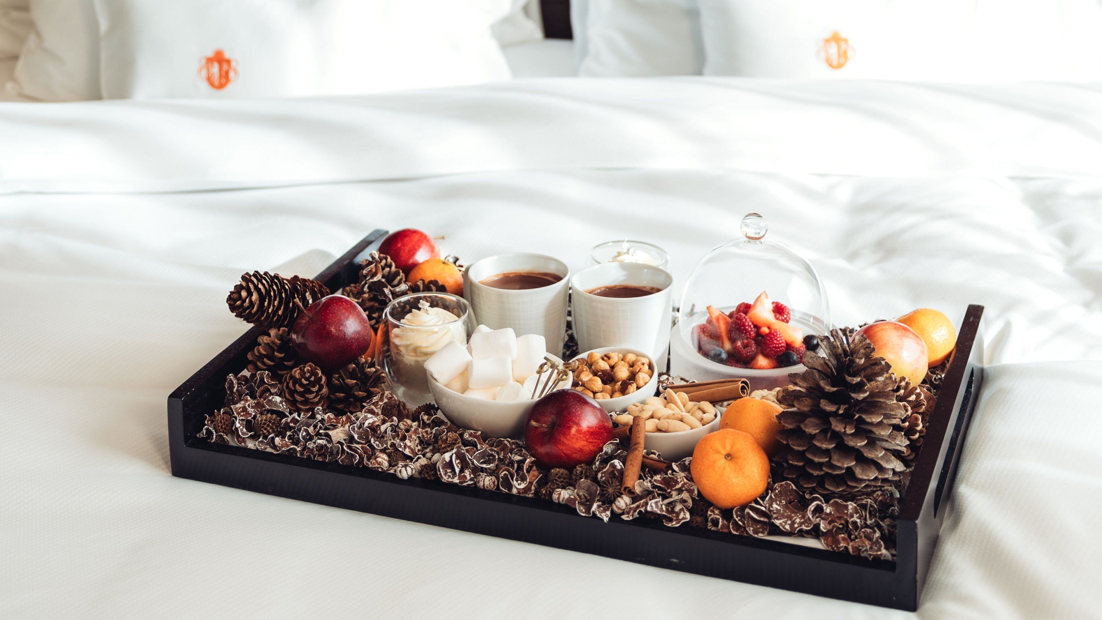 Ein Tablett mit Snacks und Getränken auf einem Bett.