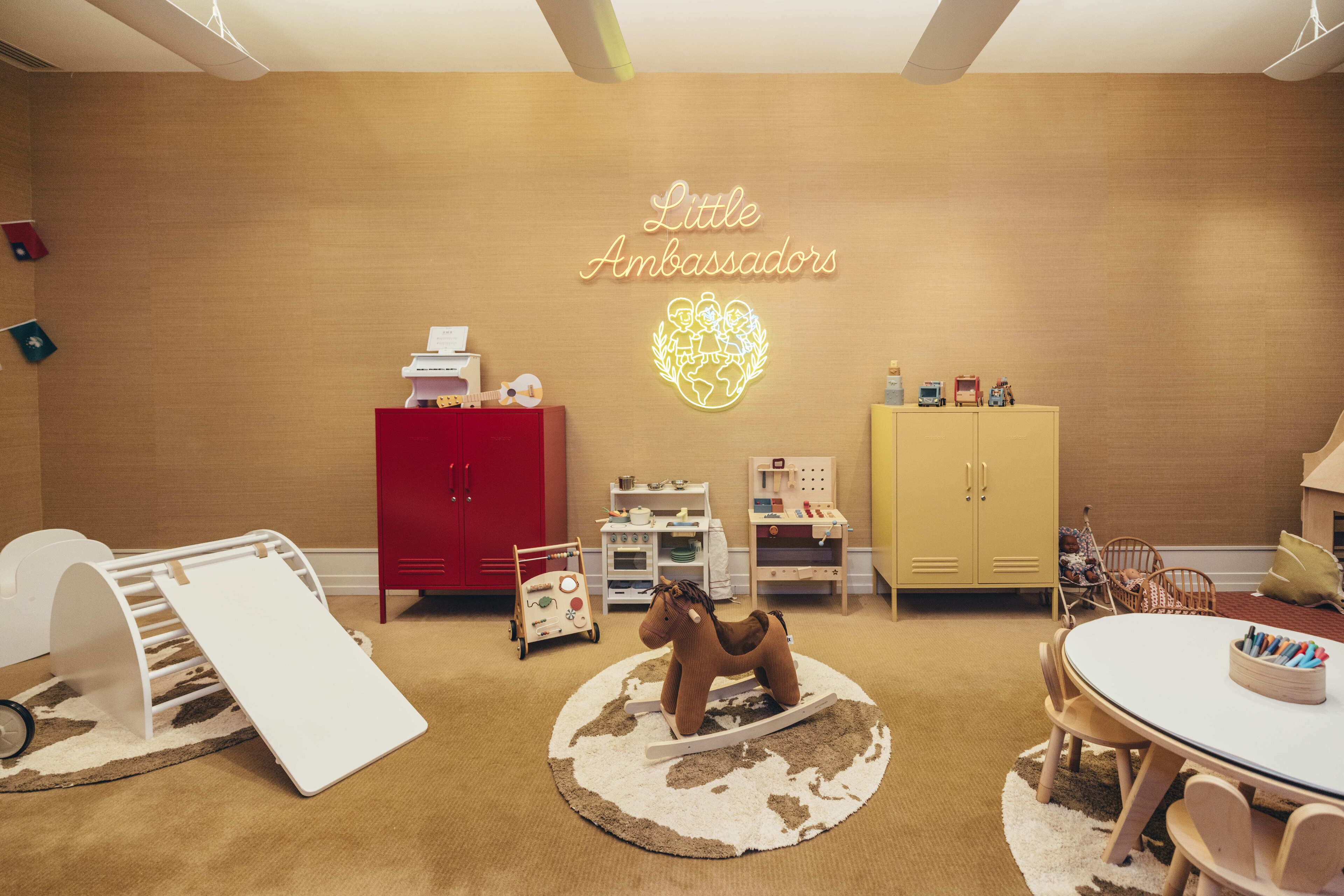 Habitación apta para niños con zona de juegos, un armario rojo, un armario amarillo y un letrero de neón que dice 