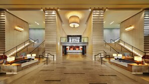 A spacious lobby with a central reception desk, two symmetrical staircases, and a modern ceiling design. - InterContinental Geneve by IHG (Geneva)