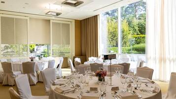 A well-lit conference room with round tables set for a meeting.