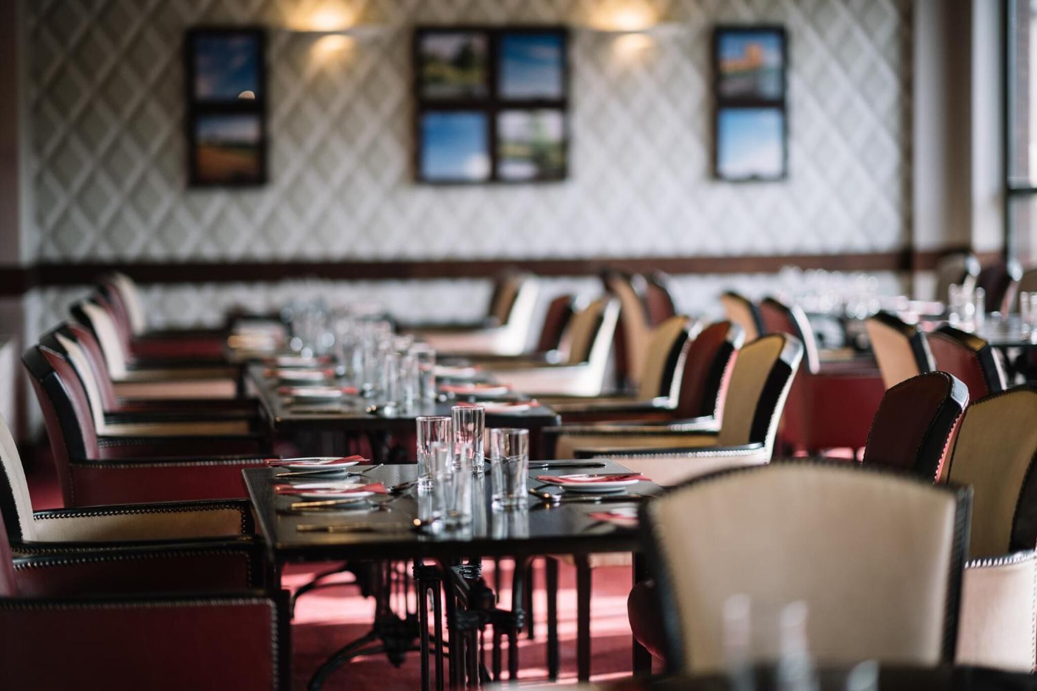 Ein Restaurant mit langen Tischen und Stühlen, die in Reihen angeordnet sind.