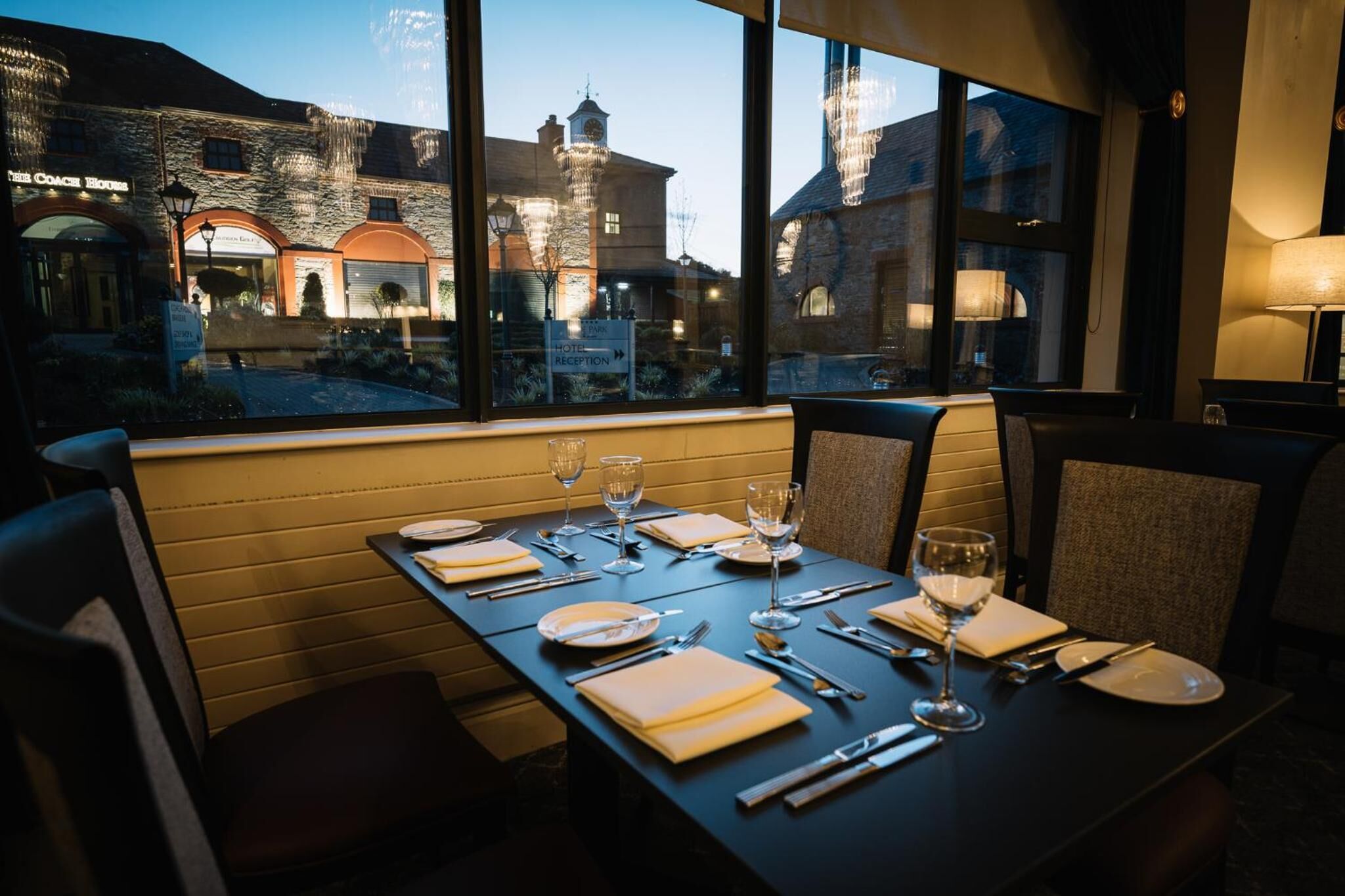 A dining table set for four with a view of a historic building outside.