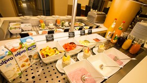 Monipuolinen buffet, jossa on tarjolla erilaisia ruokia, kuten hedelmiä, vihanneksia ja juomia.