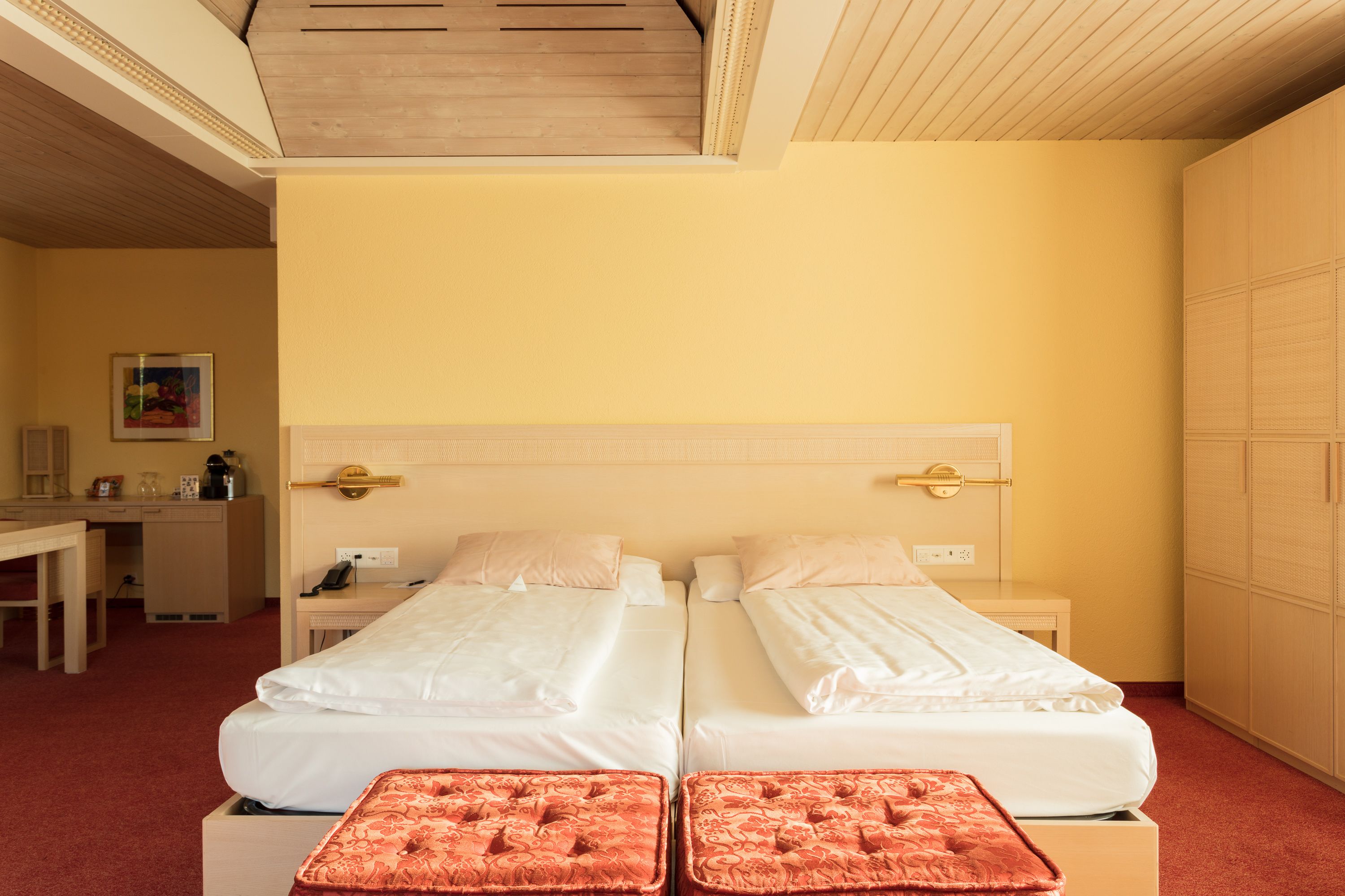 Une chambre d’hôtel avec deux lits, un bureau et une armoire.