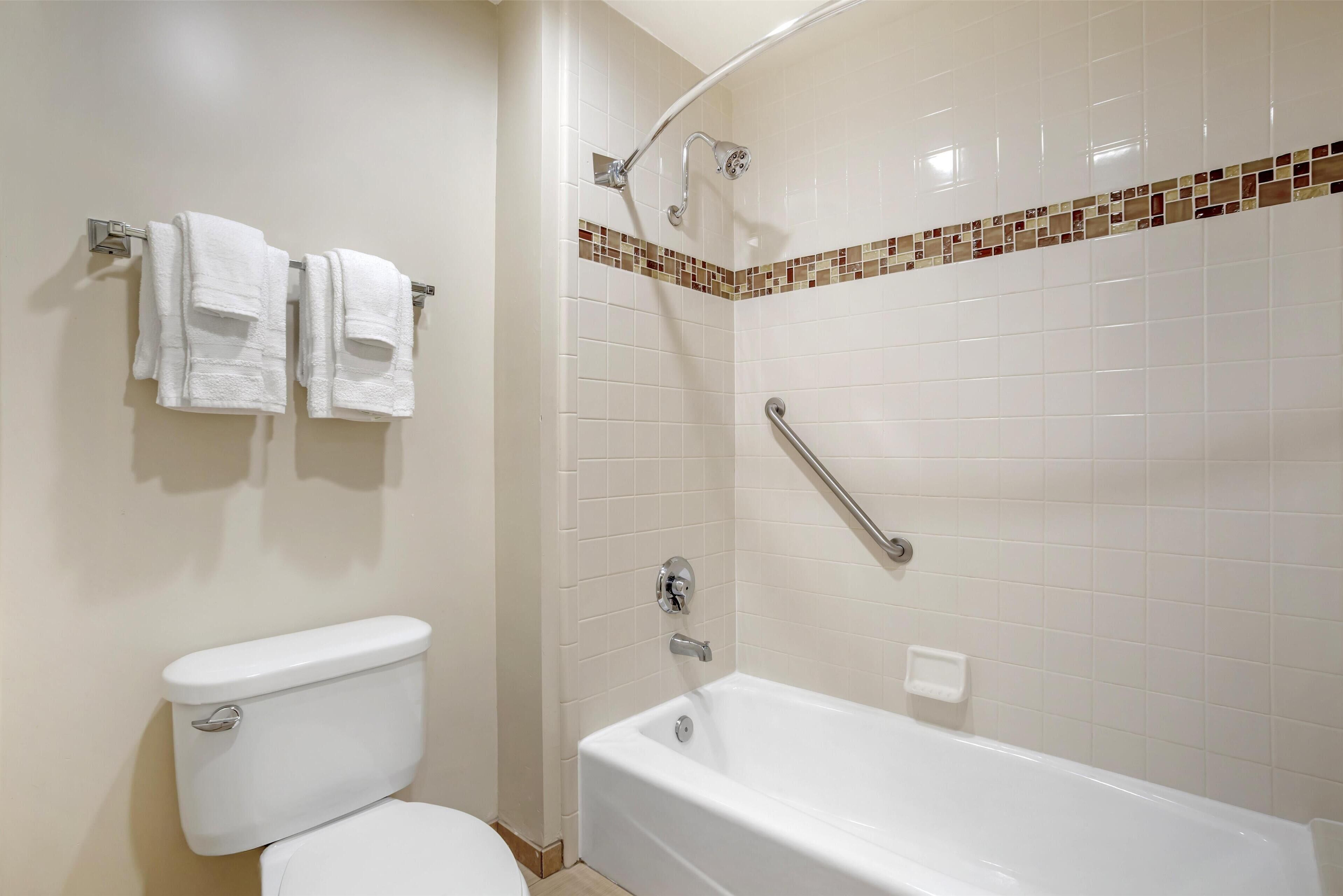 Une salle de bain équipée de toilettes, d’une baignoire et d’une douche.