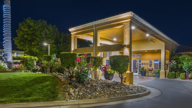 Un hôtel doté d’une entrée abritée, d’un jardin aménagé et d’une haute tour.