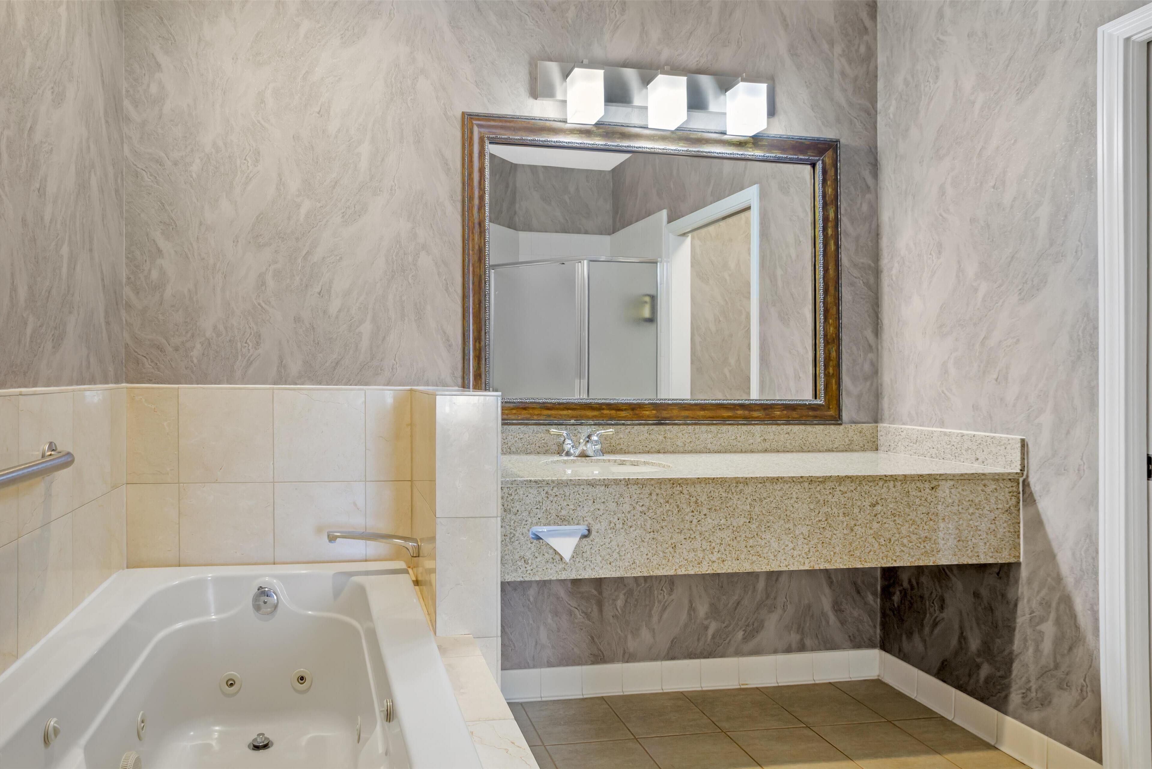 suite, 1 king bed, non smoking, jetted tub | bathroom | combined shower/bathtub, designer toiletries, hair dryer, towels