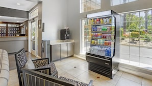 Un hall d’hôtel doté d’un espace salon, d’un distributeur automatique et offrant une vue sur l’extérieur.