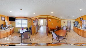 A spacious restaurant with a curved counter, multiple seating areas, and a television mounted on the wall. - Econo Lodge Inn & Suites Albuquerque East I-40 Eubank Exit (Albuquerque)