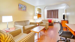 A hotel room with a sofa set, a desk, a TV, and a lamp. - Econo Lodge Inn & Suites Albuquerque East I-40 Eubank Exit (Albuquerque)