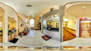 A hotel lobby with a reception desk, seating area, and a staircase leading to other floors. - Econo Lodge Inn & Suites Albuquerque East I-40 Eubank Exit (Albuquerque)