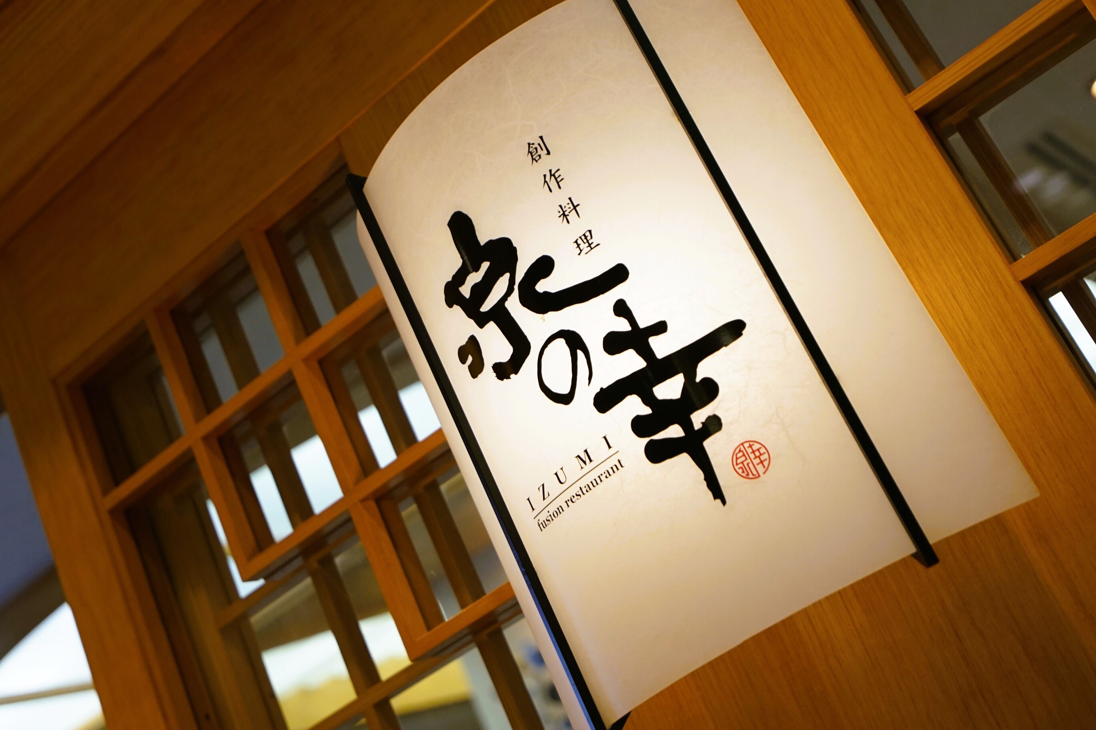 A sign with Japanese characters and the name "IZUMI" indicating a restaurant.