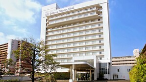 Un hotel de varios pisos con fachada blanca y entrada cubierta.