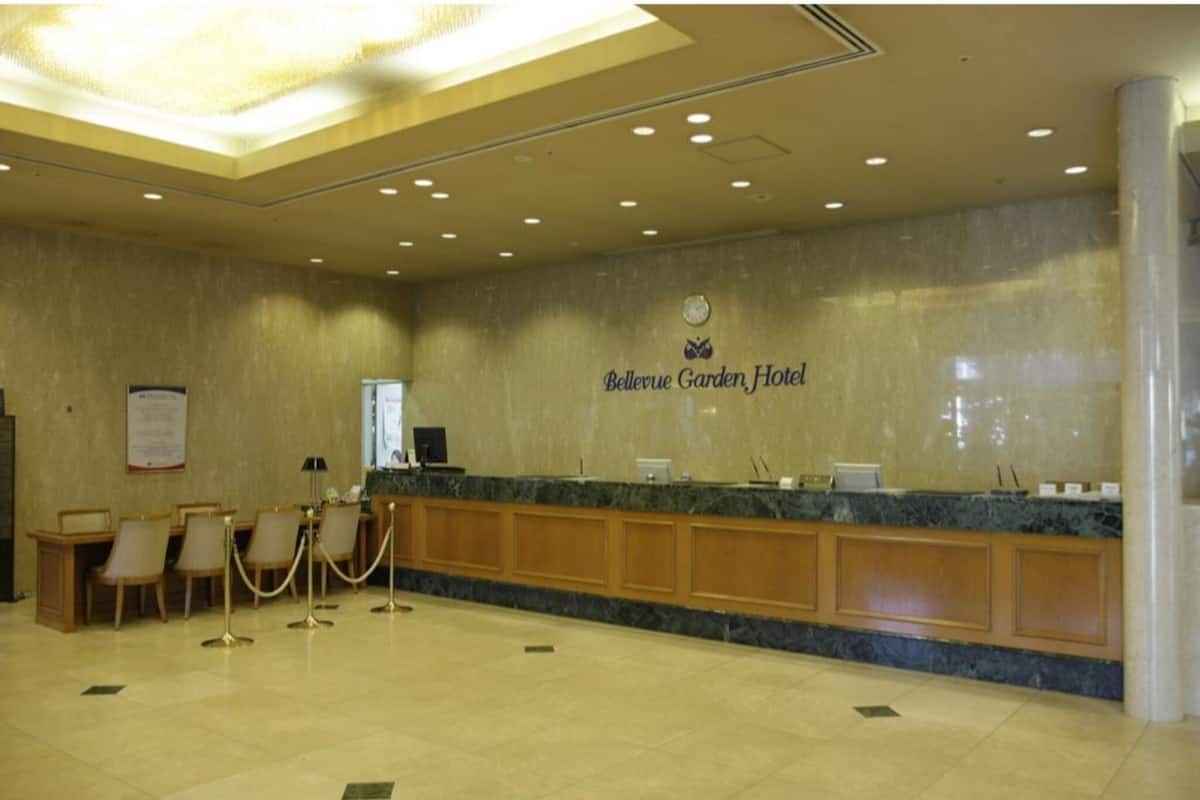 A reception area with a marble counter, wooden paneling, and a clock on the wall.