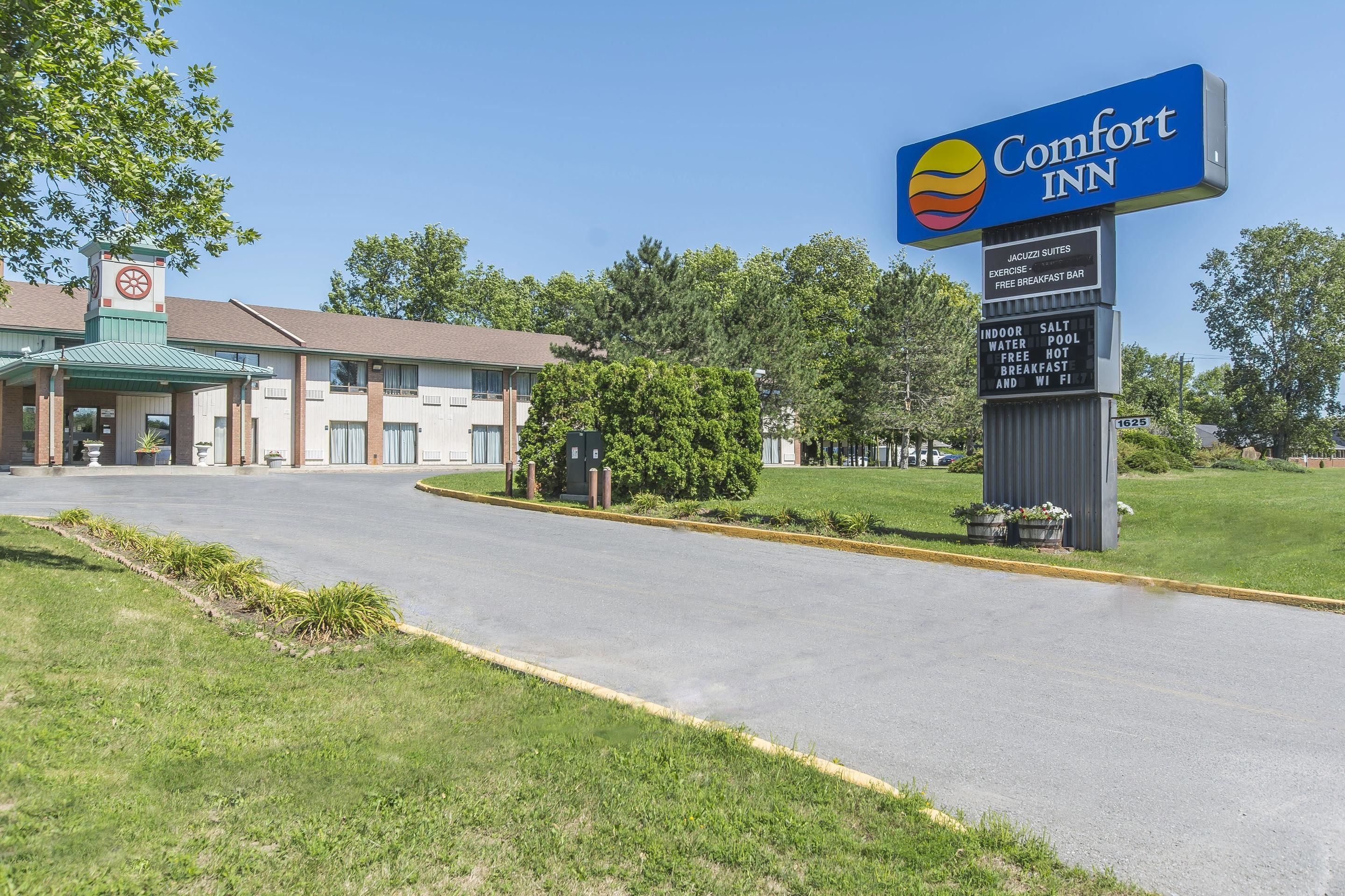 A Comfort Inn hotel with a signboard listing amenities like indoor salt, water, pool, free breakfast, and WiFi.
