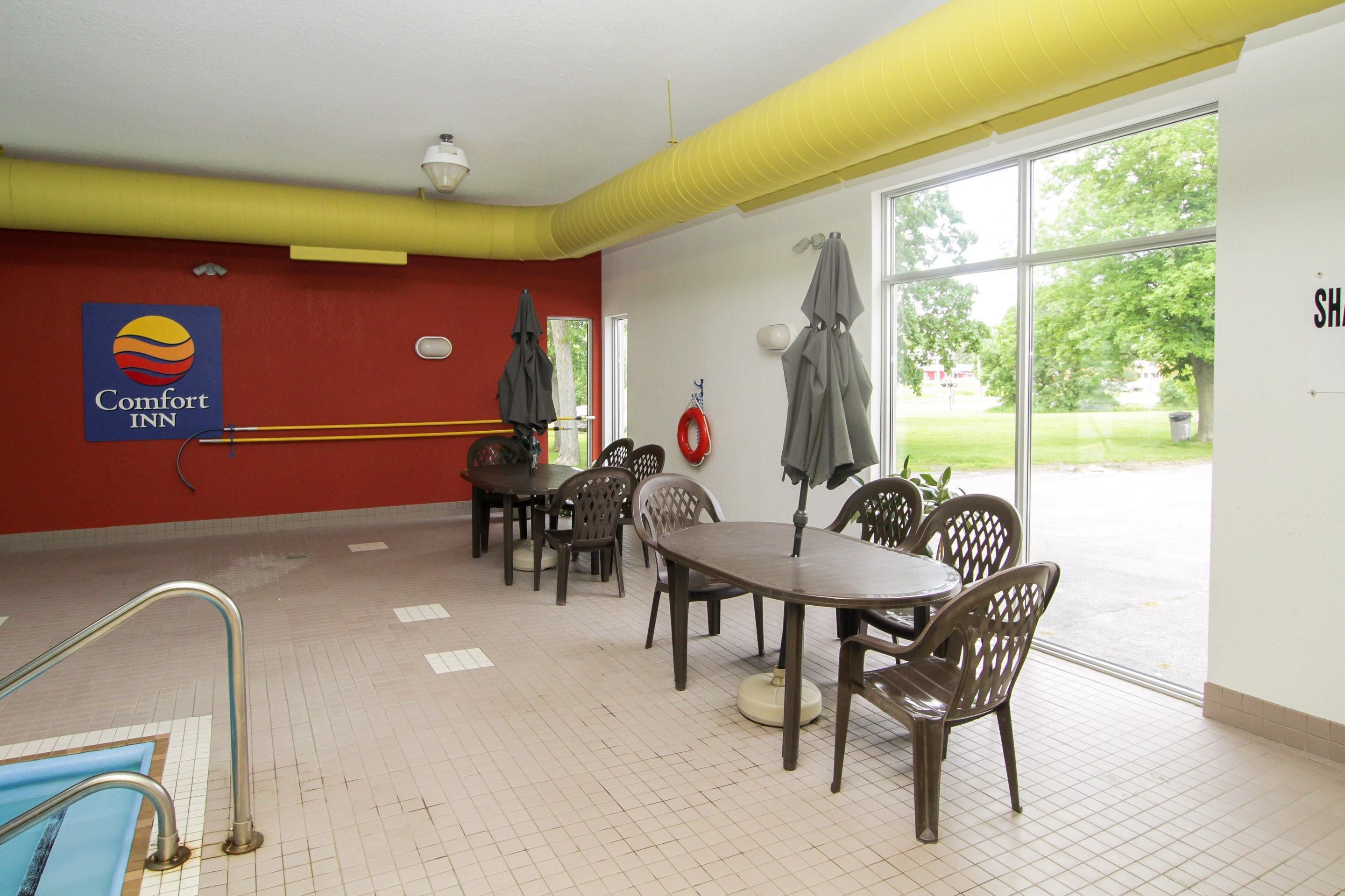 Comedor de Comfort Inn con mesas y sillas, un extintor y vistas al exterior.