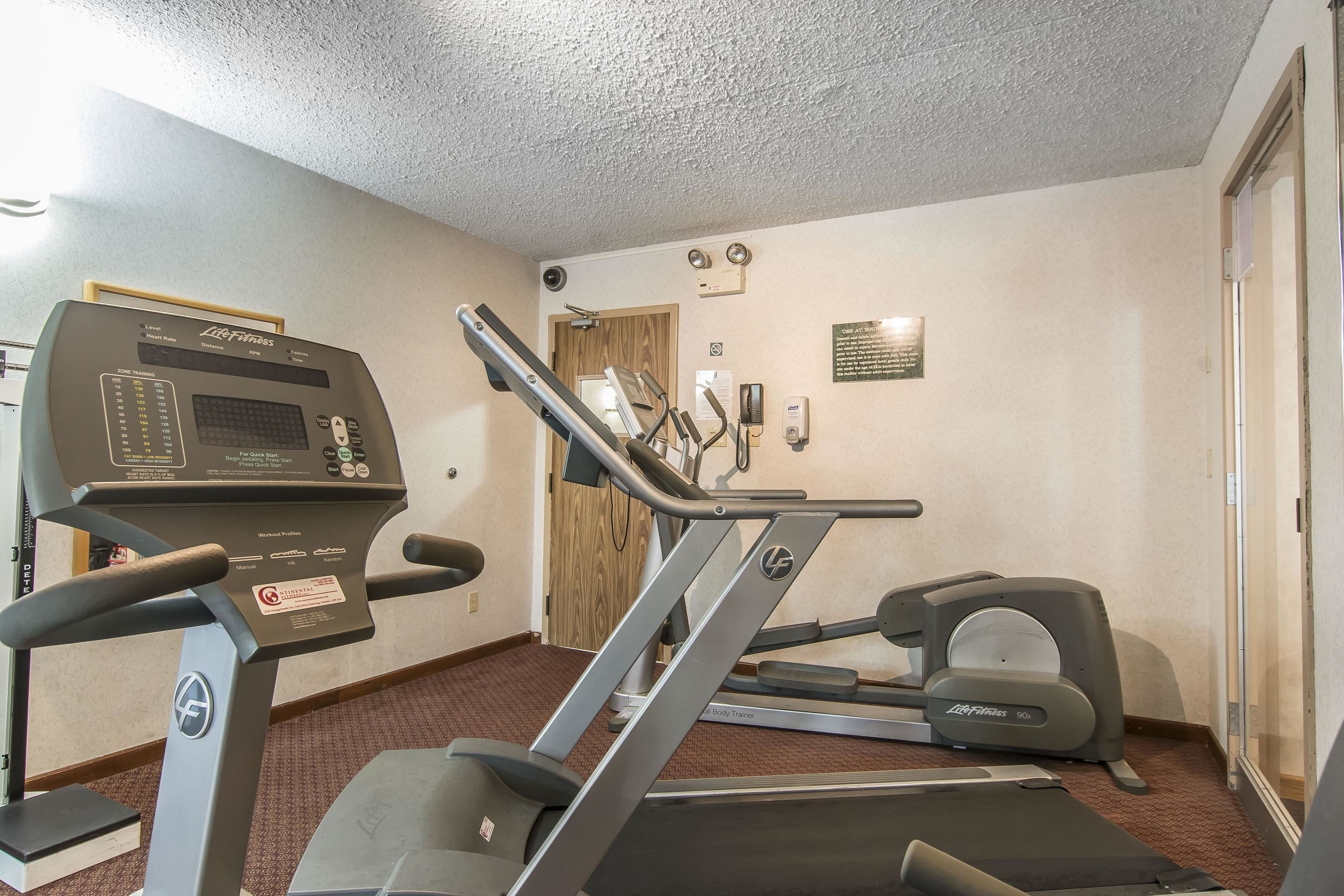 A gym with treadmills, an elliptical, and a stationary bike.