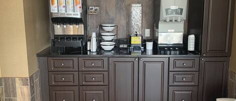 Una cocina moderna con estación de café, que incluye una cafetera y dispensador de agua.