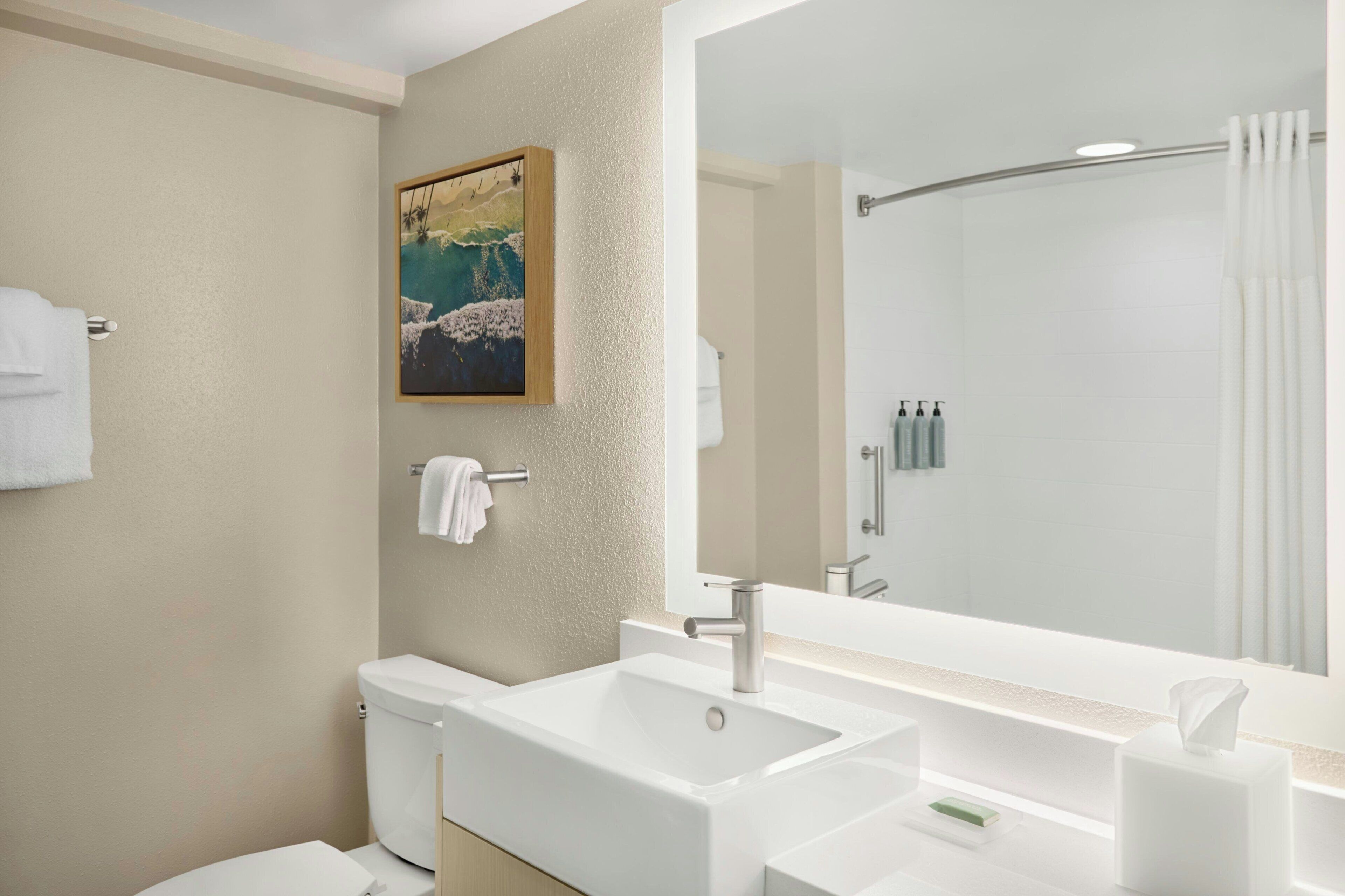 A bathroom with a large sink, toilet, and shower.