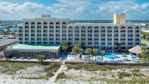 Ein großes Hotel mit mehreren Etagen, einem Swimmingpool und einer Strandanlage.