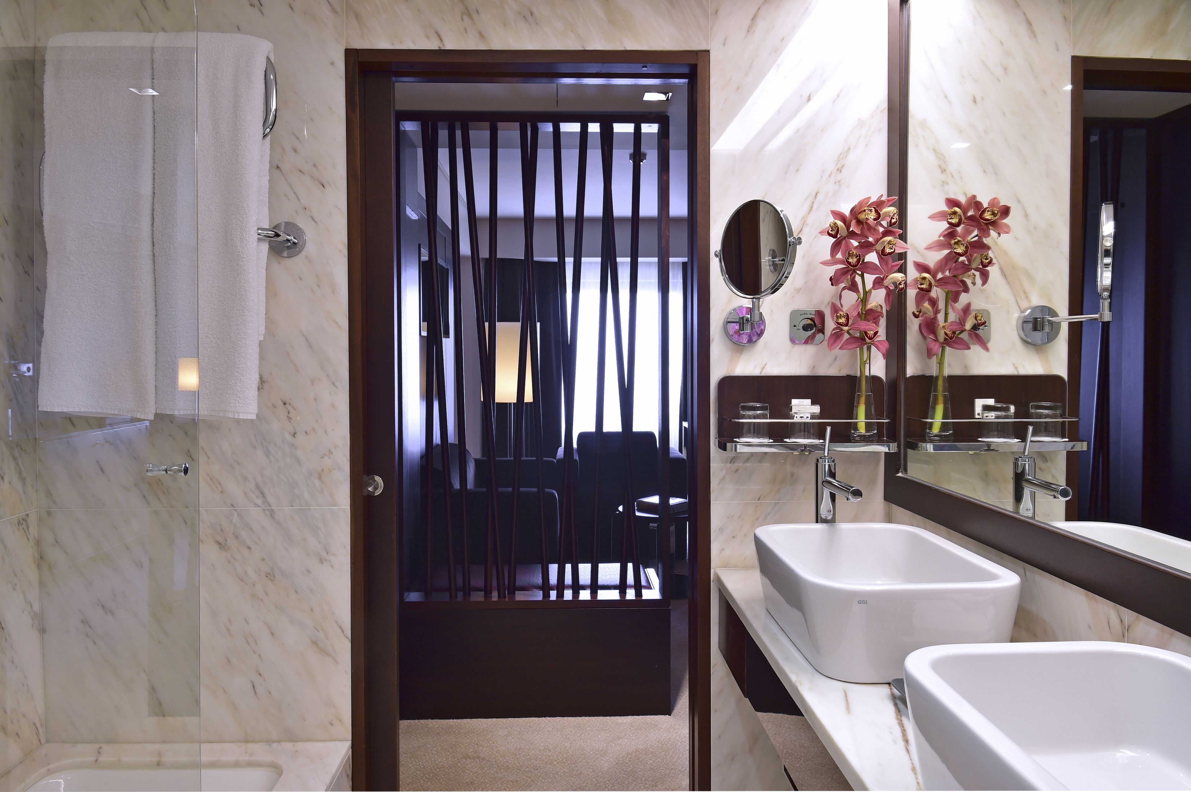 Une salle de bain avec deux lavabos, un grand miroir et un porte-serviettes.