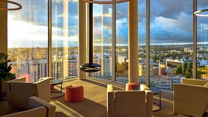 A modern hotel room with large windows, a circular light fixture, and comfortable seating. - Porto Palácio Hotel by The Editory (Porto)