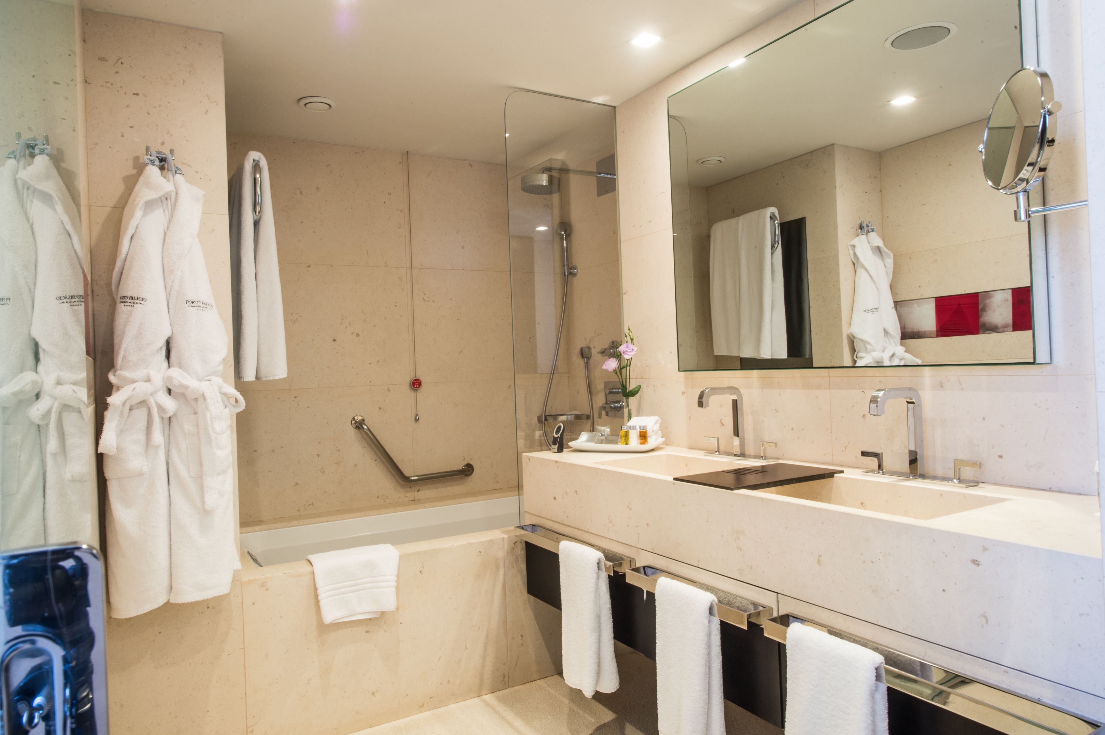 Une salle de bain moderne dotée d’une douche à parois de verre, d’un meuble-lavabo à deux vasques et d’un grand miroir.
