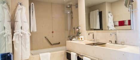 Un baño moderno con cabina de ducha de vidrio, tocador doble y un espejo grande.
