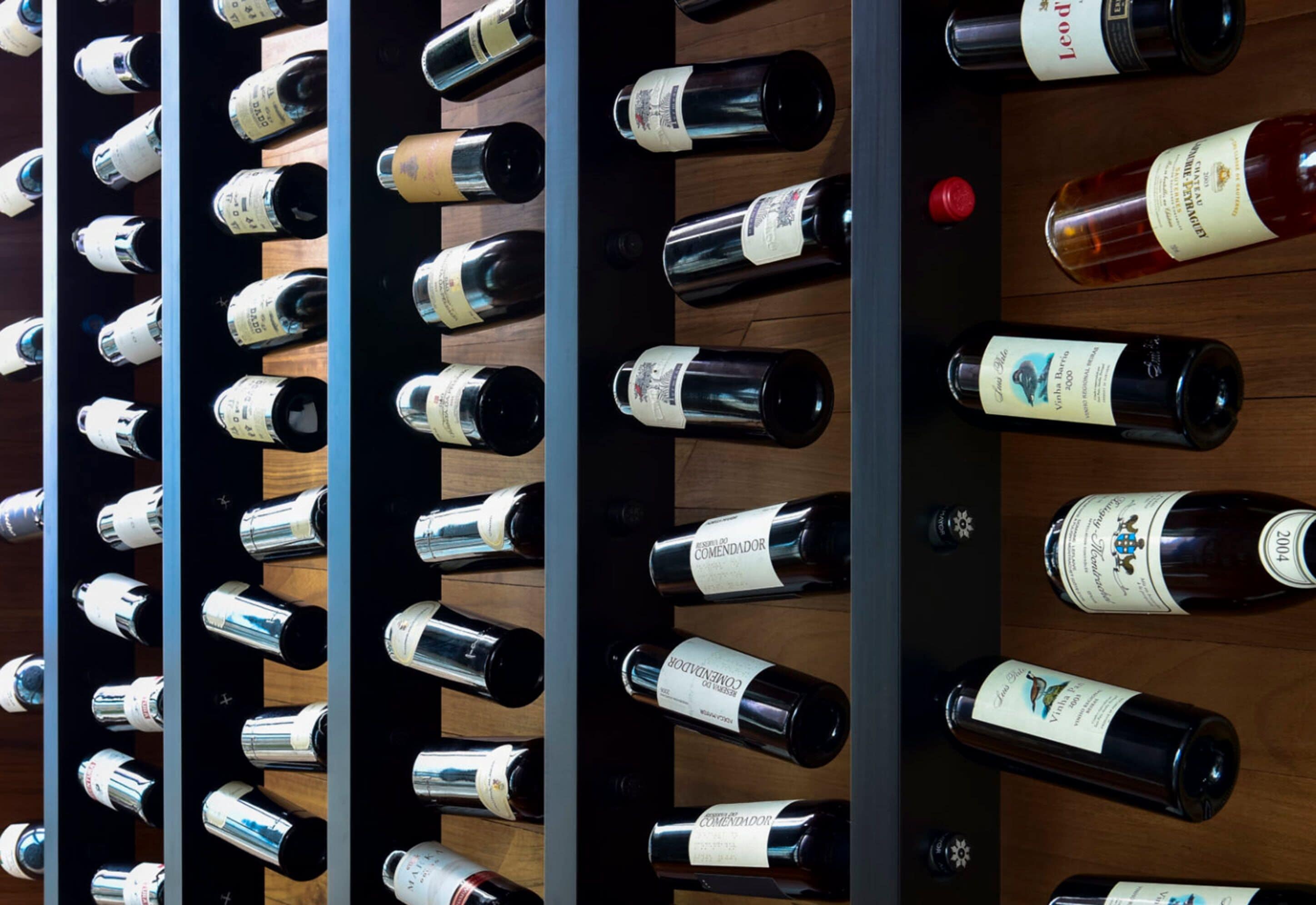 Una botellera con varias botellas, cada una con su etiqueta.