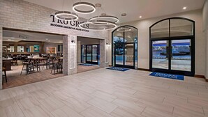 A spacious lobby with a modern American Asian kitchen, a craft beer bar, and a view through large glass doors. - Four Points by Sheraton Anaheim (Anaheim)