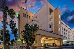 A hotel with a modern architectural design, featuring a prominent entrance and a parking area. - Holiday Inn Express & Suites Anaheim Convention Center Area by IHG (Anaheim)
