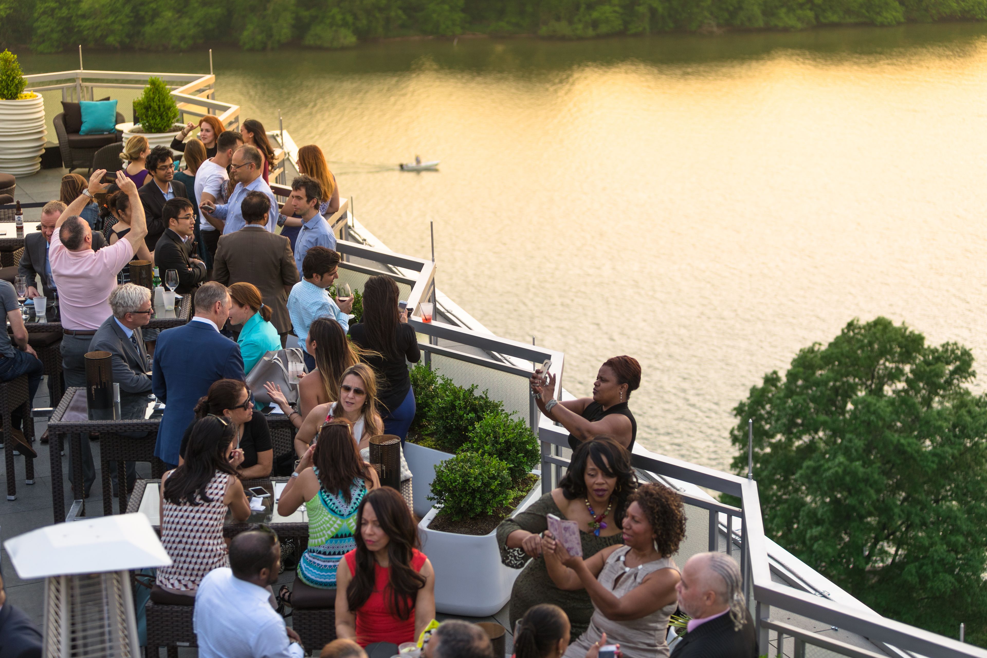A group of people on a boat deck with a view of a calm lake.