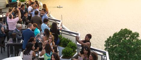 A group of people on a boat deck with a view of a calm lake.