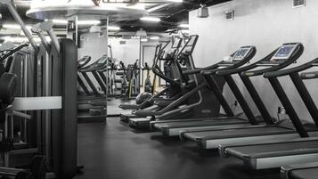 Un gimnasio con cintas de correr y máquinas de ejercicio.