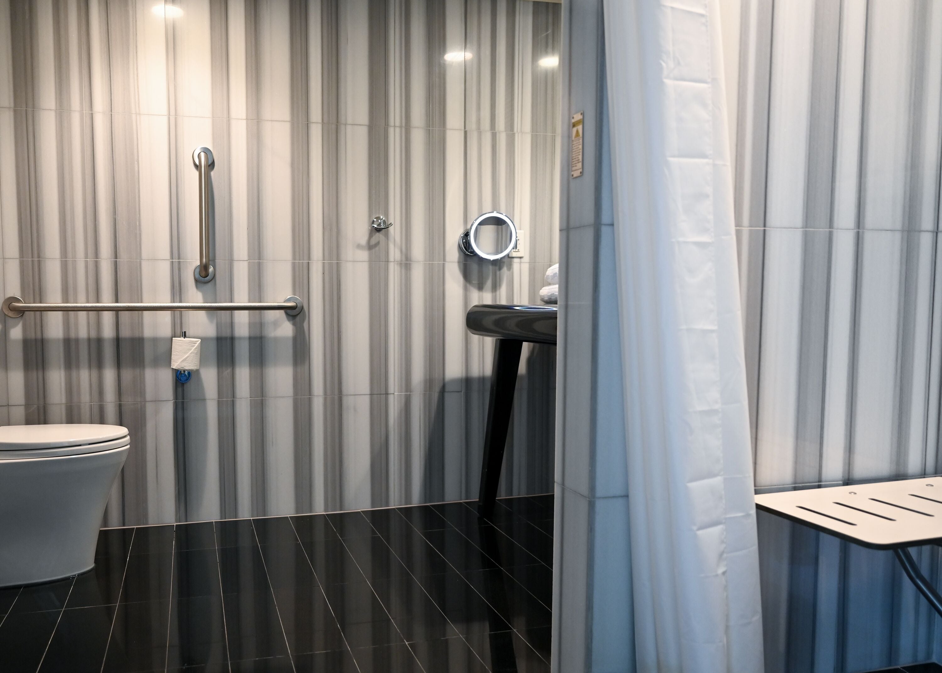 A modern bathroom with a toilet, a sink, and a shower area.