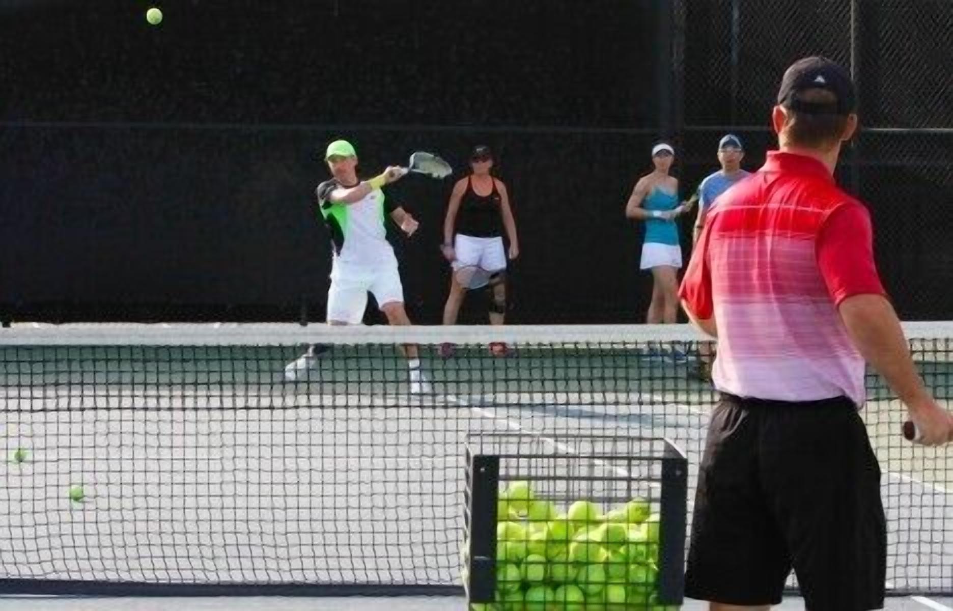 Una cancha de tenis con jugadores y una red.