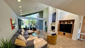 A spacious living area with a large sofa, a coffee table, and a fireplace. - Shadow Mountain Resort (Palm Desert)