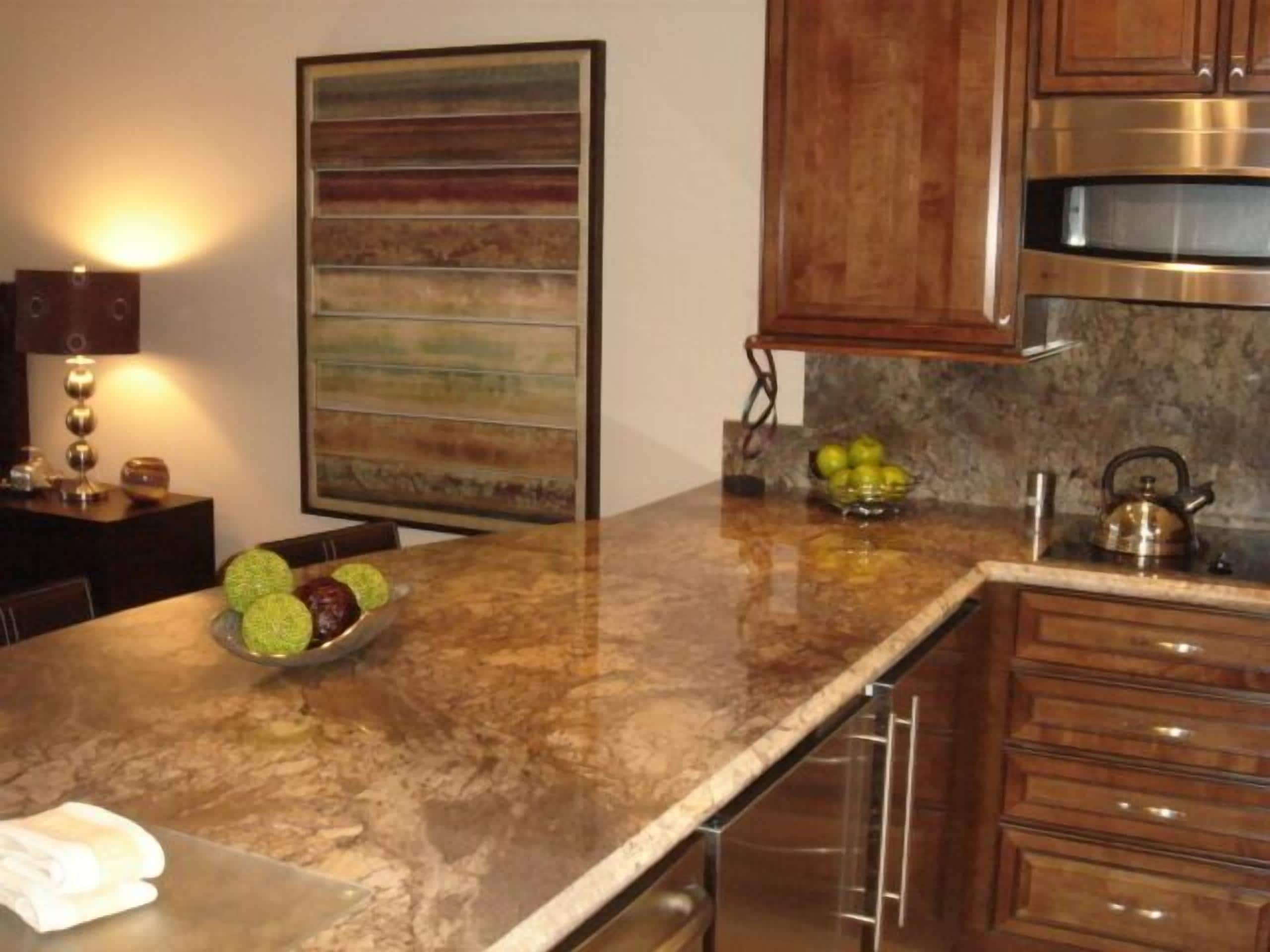 A kitchen with a granite countertop, stainless steel appliances, and wooden cabinets.