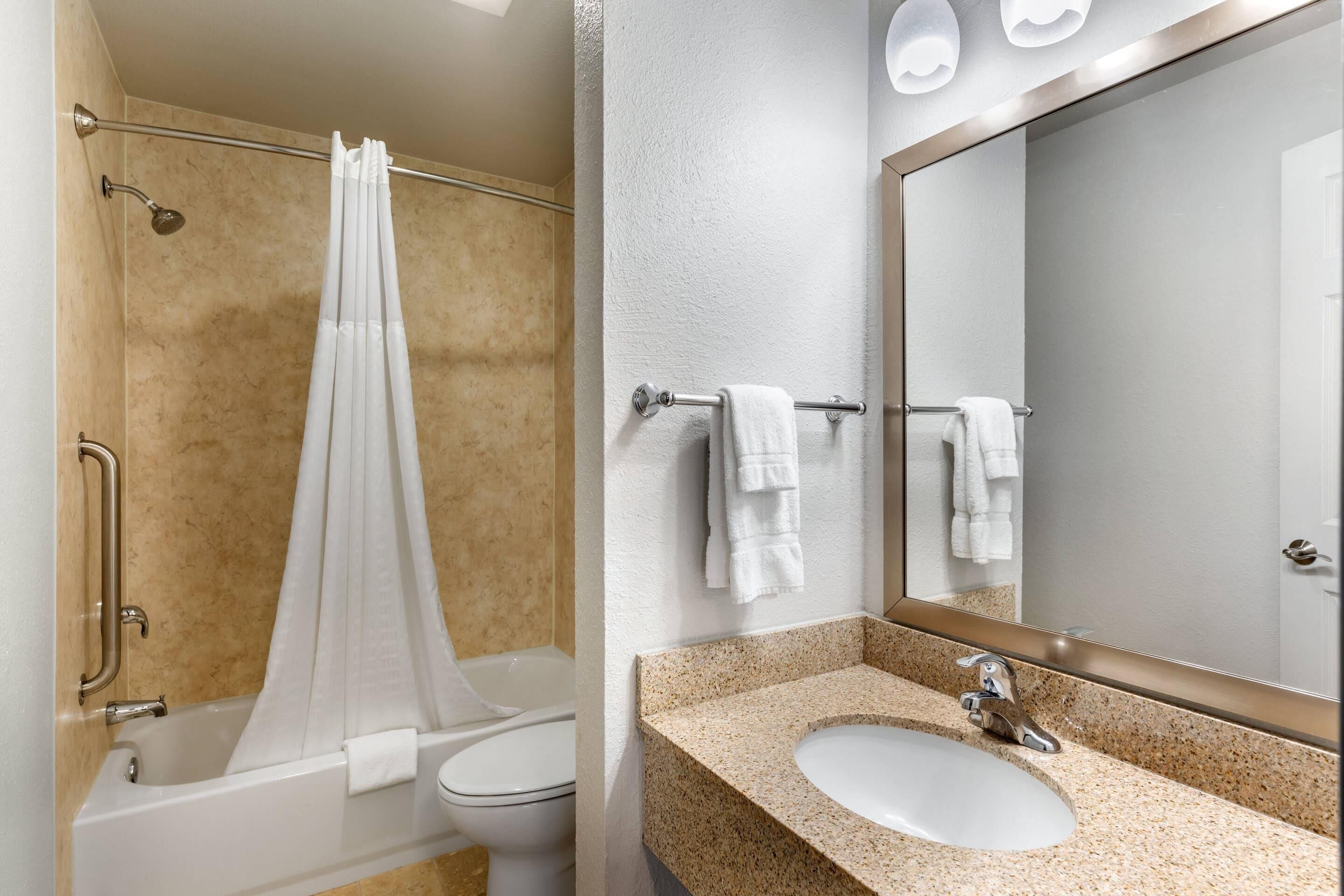 A bathroom with a bathtub, toilet, and sink.