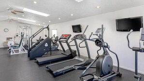 A gym with treadmills, elliptical machines, and weight machines.