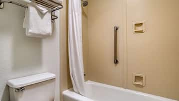 Un bagno con il water, una doccia dotata di maniglione e un portasciugamani.