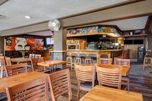 Enjoy a casual dining experience with wooden tables, a bar, and a TV for entertainment.