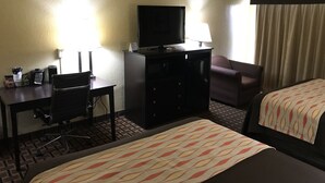A hotel room with a desk, a television, a chair, a bed, and a window with curtains. - Days Inn by Wyndham Joplin (Joplin)