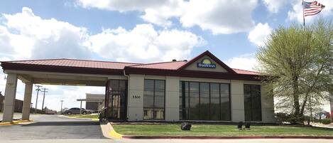 A Days Inn with a red roof, large windows, and an American flag.